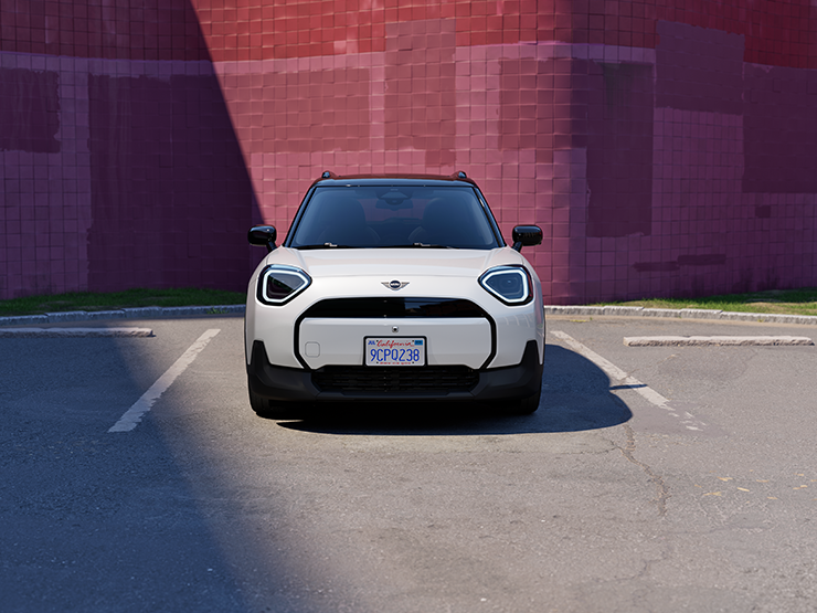 Vooraanzicht van een parkerende MINI Aceman Electric in Nanuq White met dak in Black.