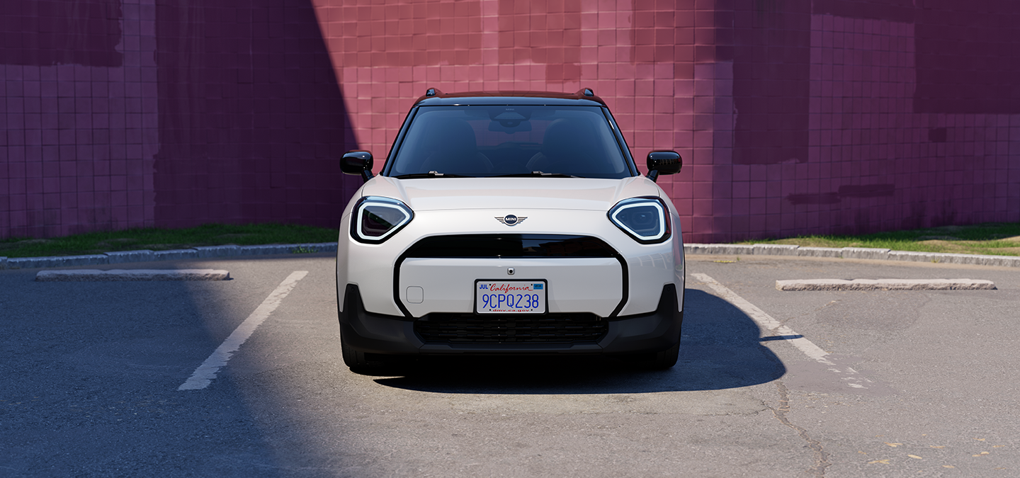 Vooraanzicht van een parkerende MINI Aceman Electric in Nanuq White met dak in Black.