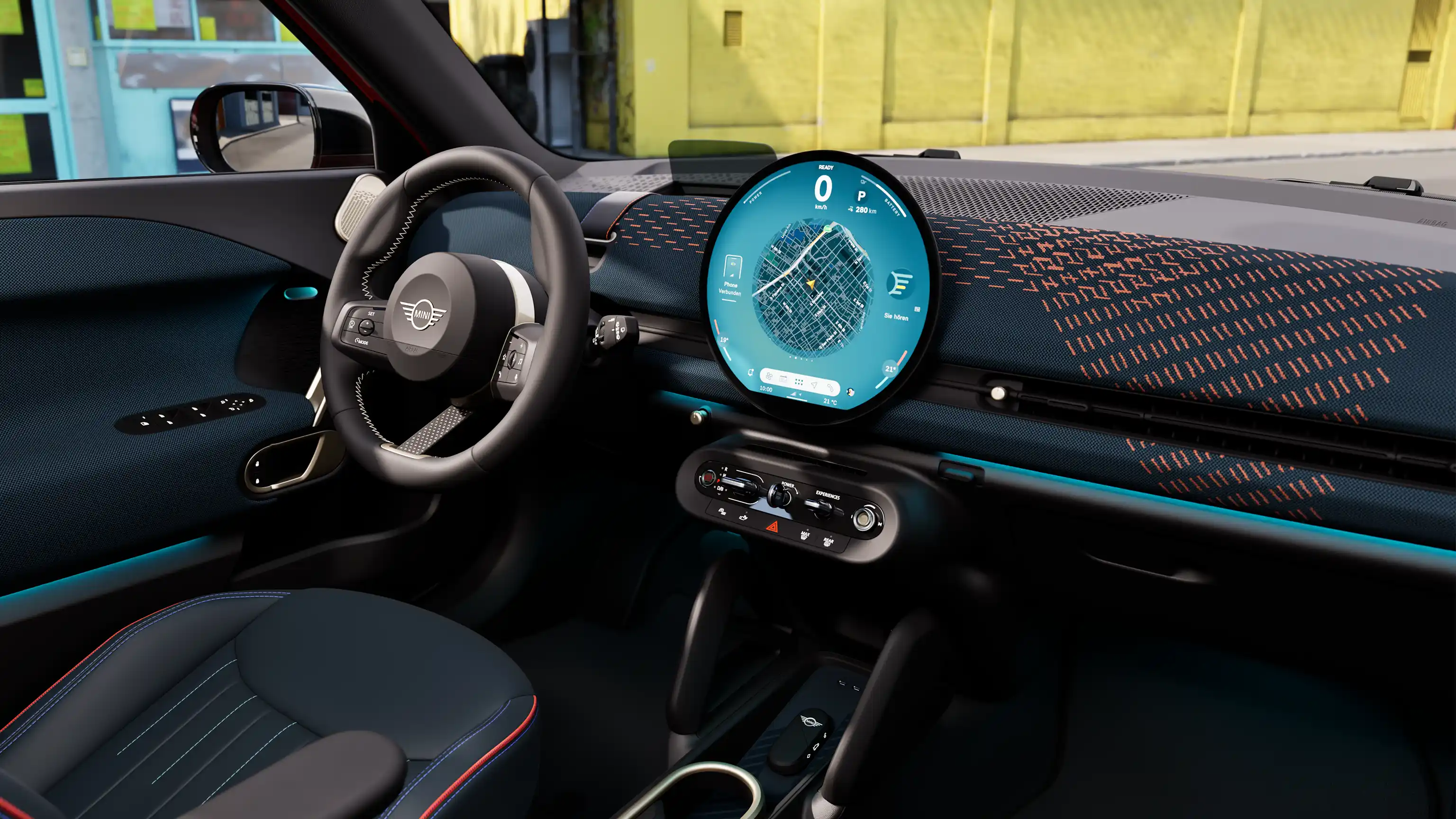 Panoramisch zicht op het dashboard van de MINI Aceman Electric met gele muur op de achtergrond
