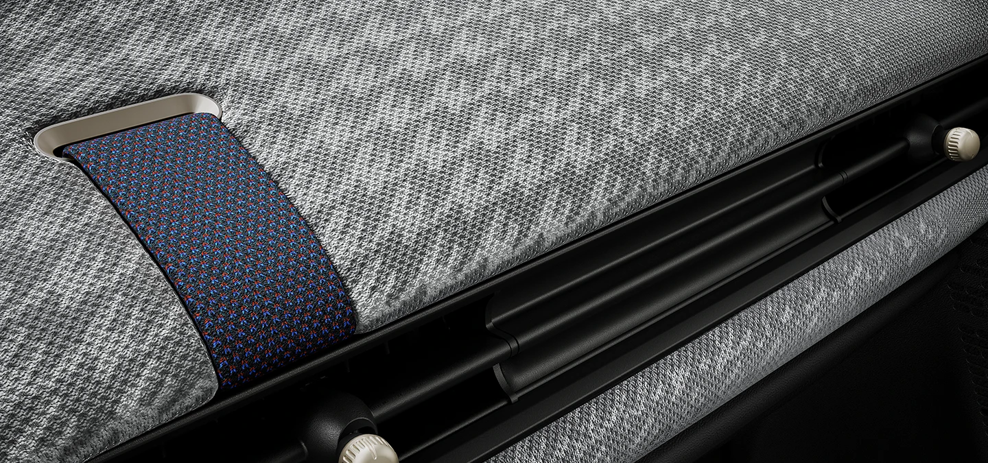 Close-up van het 2D-gebreide dashboard aan de binnenkant van de MINI Cooper.