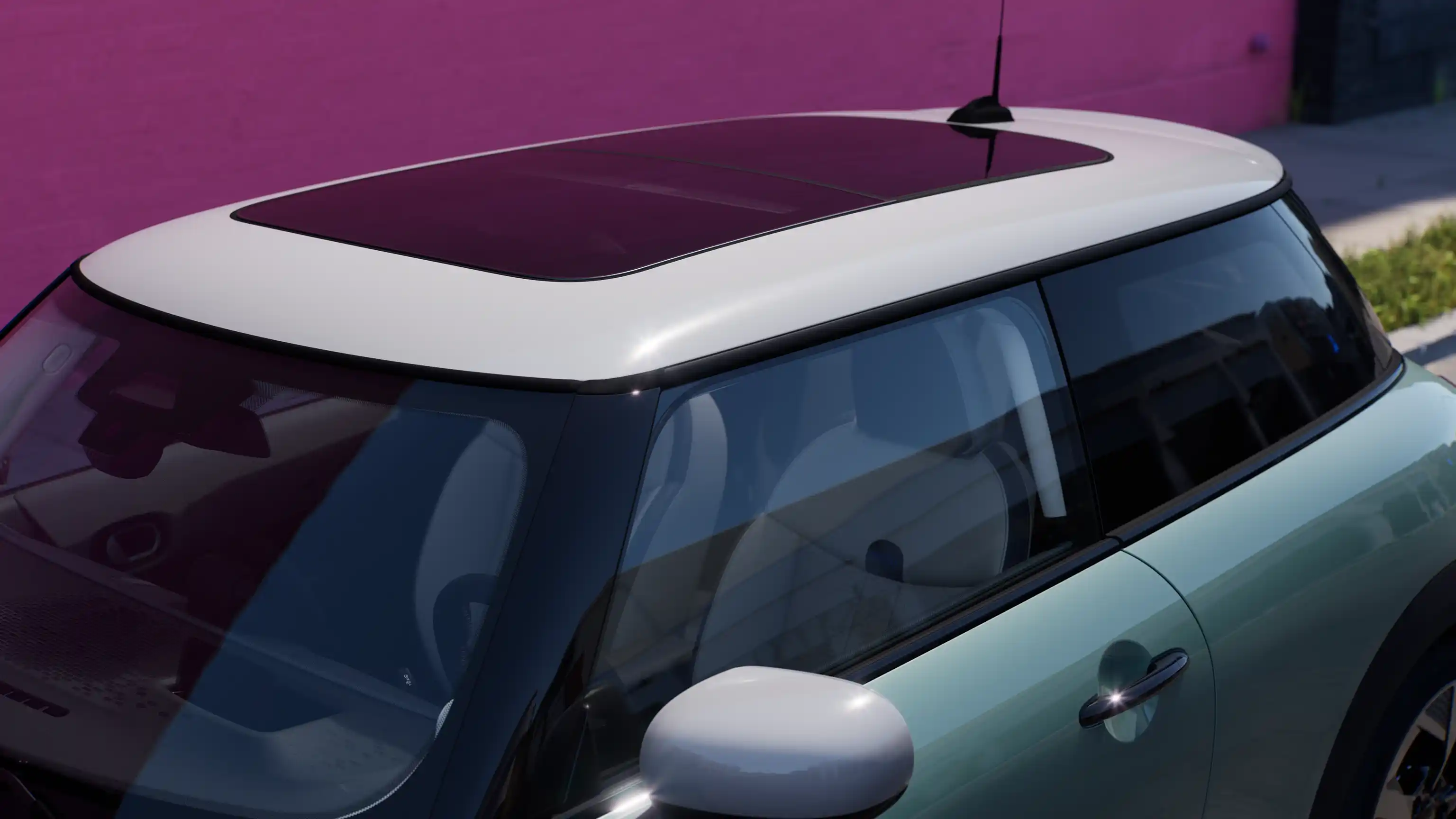 Bovenaanzicht van de MINI Cooper in Ocean Wave Green met contrasterend, groot glazen dak.