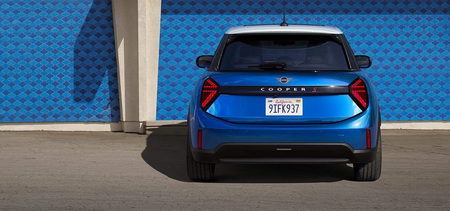 Achteraanzicht van de MINI Cooper 5-deurs in Icy Sunshine Blue met dak in Multitone Blue.