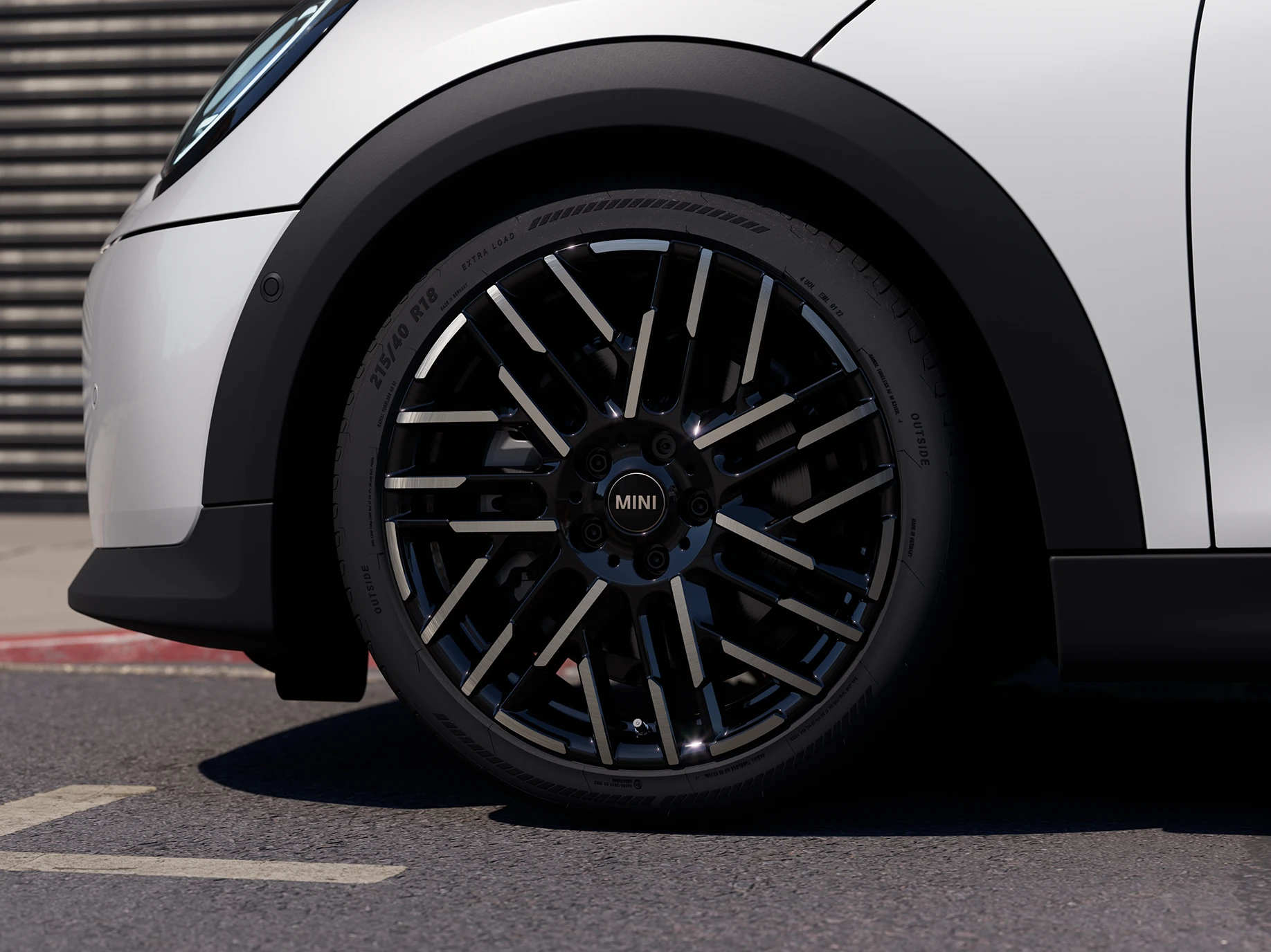 Van dichtbij opgenomen video van de MINI Cooper 5-deurs in Nanuq White met 2-kleurige velgen met Night Flash-spaak.