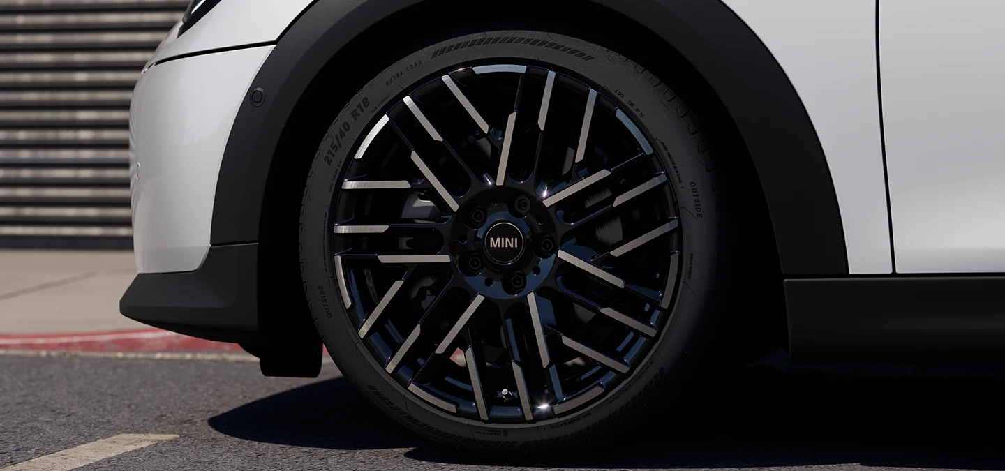 Van dichtbij opgenomen video van de MINI Cooper 5-deurs in Nanuq White met 2-kleurige velgen met Night Flash-spaak.