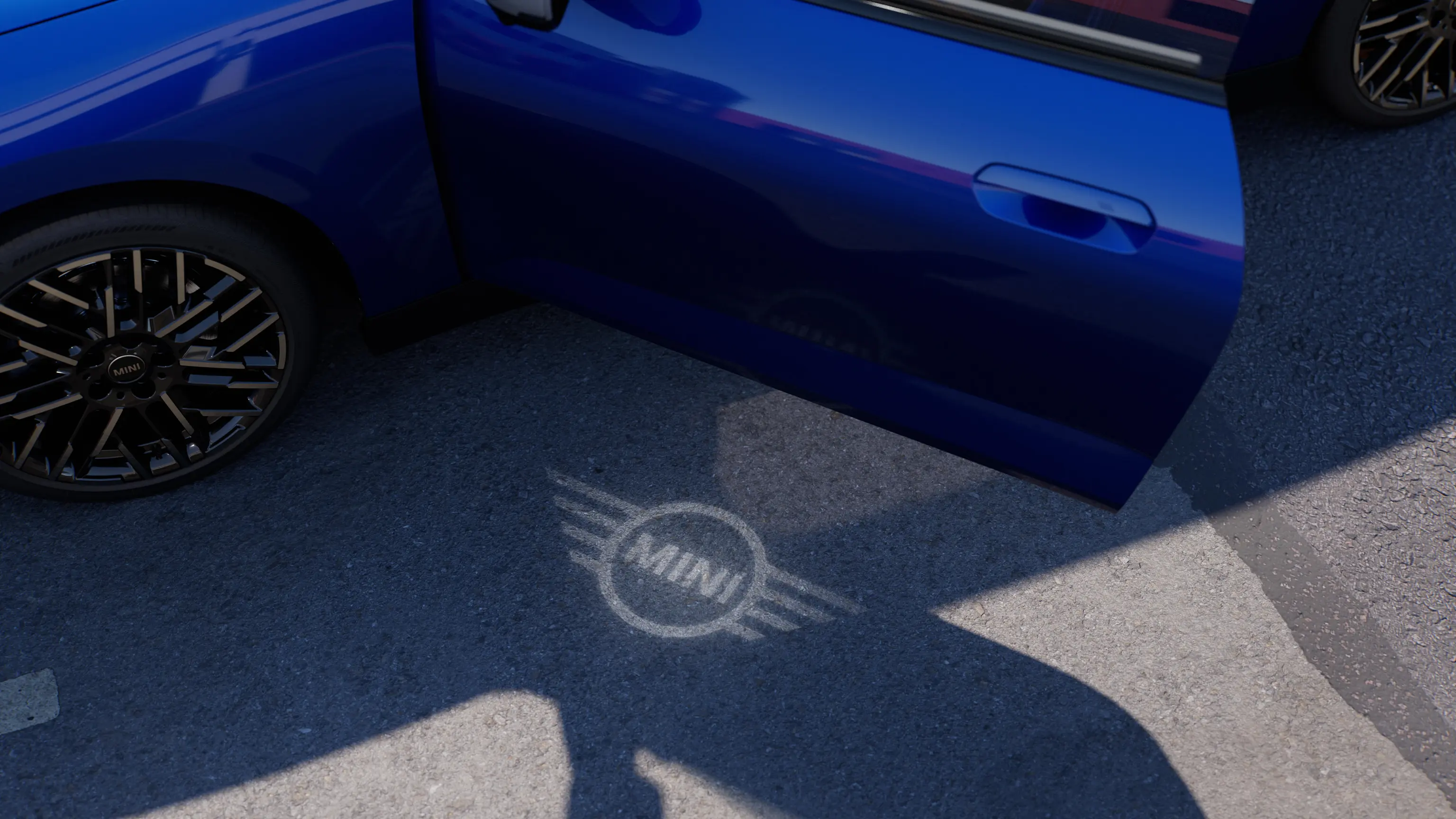 Exterieurbeeld van elektrische MINI Cooper met geopend portier en begroetingsverlichting met MINI logo op de grond