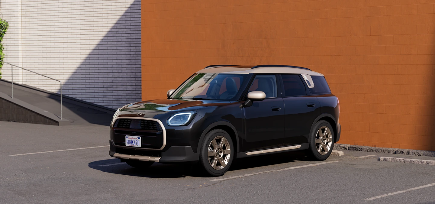 Zijaanzicht van de voorkant van de MINI Countryman in Midnight Black met dak in Vibrant Silver.