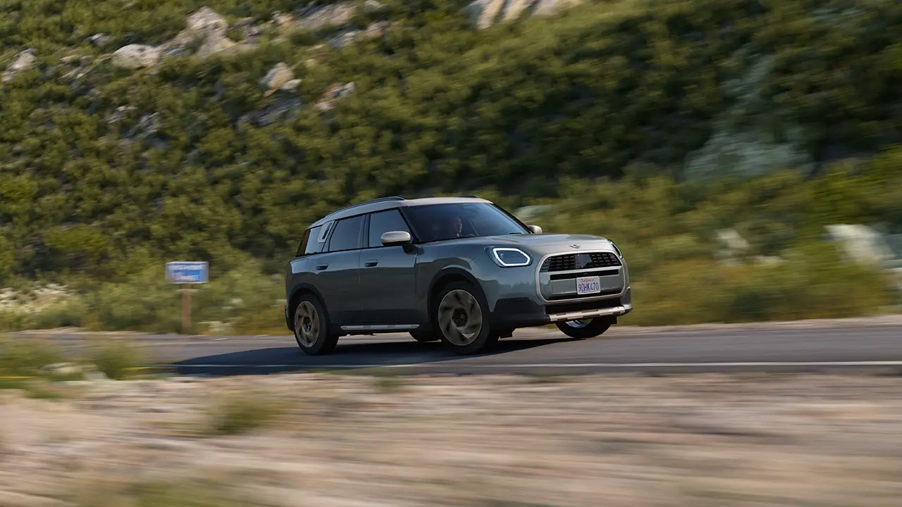 Zicht op een off-road rijdende MINI Countryman in Smokey Green met Favoured uitvoering