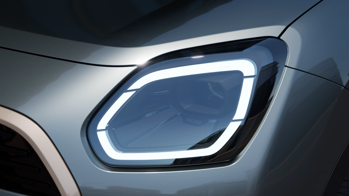 Gedetailleerde weergave van de koplamp van de MINI Countryman met wit licht aan