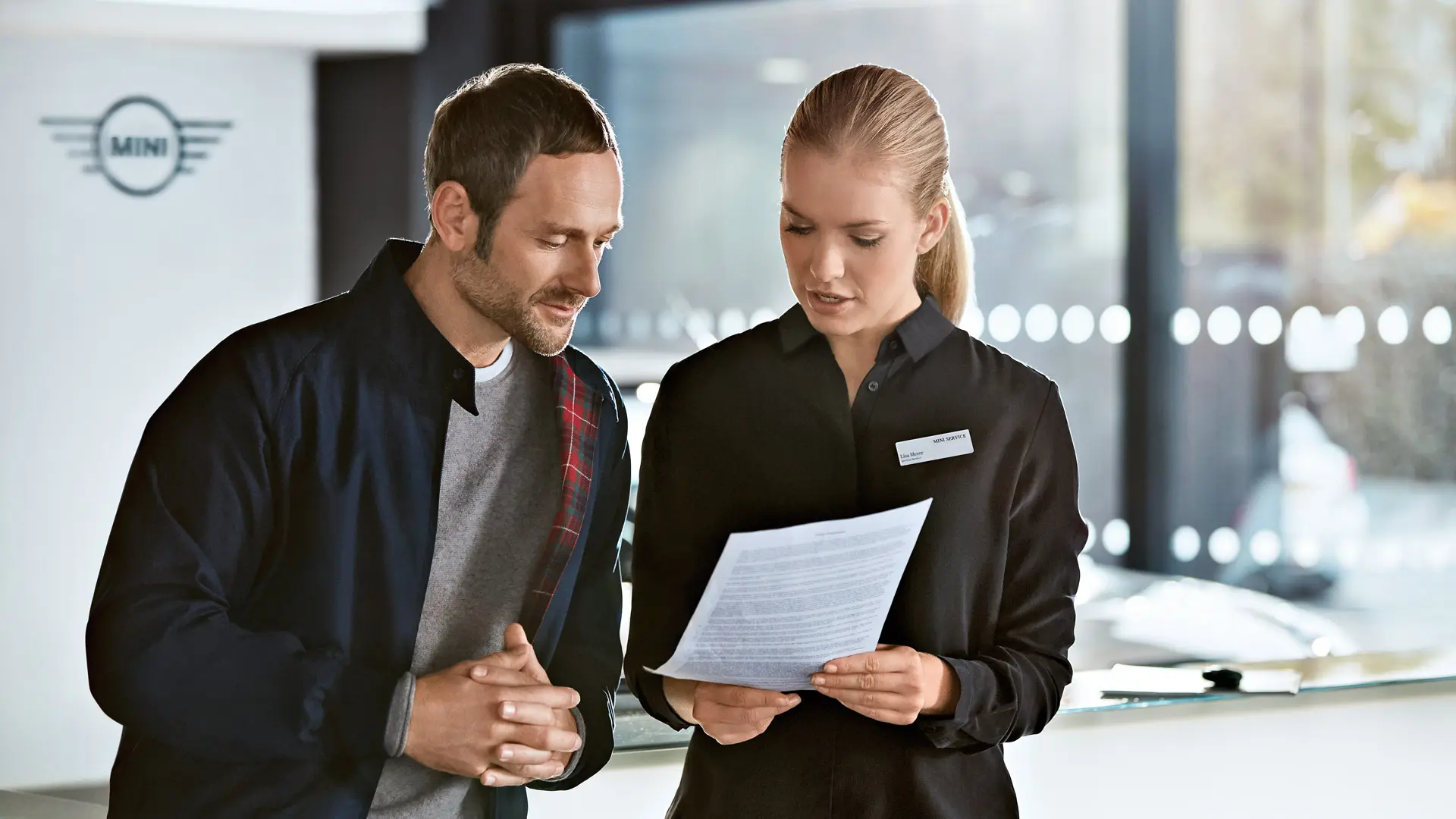 MINI service-adviseur die klanten adviseert over serviceplannen bij de MINI dealer.