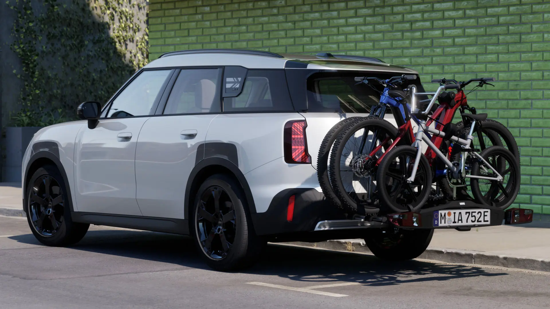 MINI Aceman in Nanuq White uitgerust met MINI fietsendrager achter Pro 3.0 met twee mountainbikes en een kinderfiets.