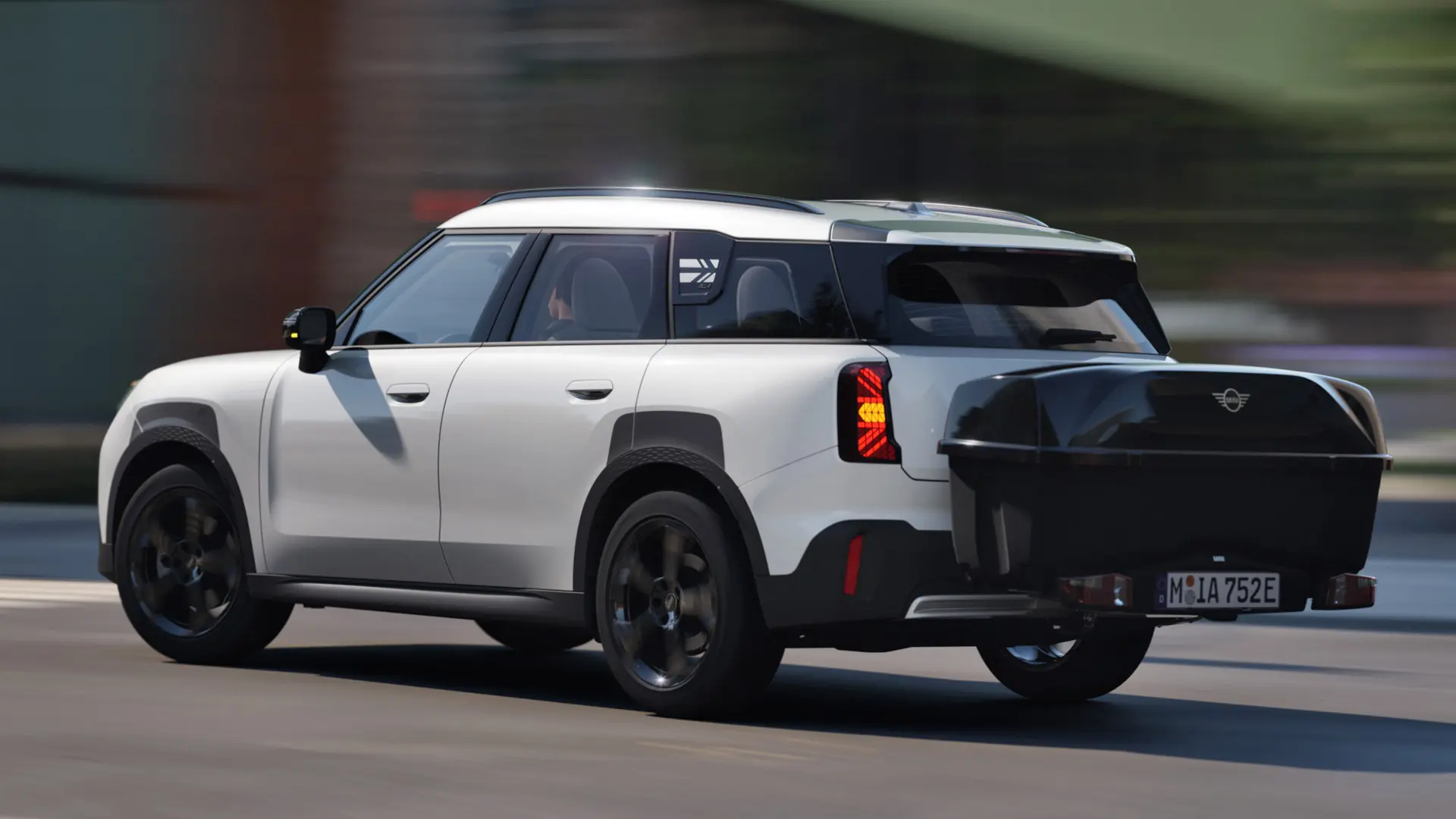 Achteraanzicht van MINI Aceman in Nanuq White, uitgerust met een MINI fietsendrager voor achter en daarop de MINI achterbox. 