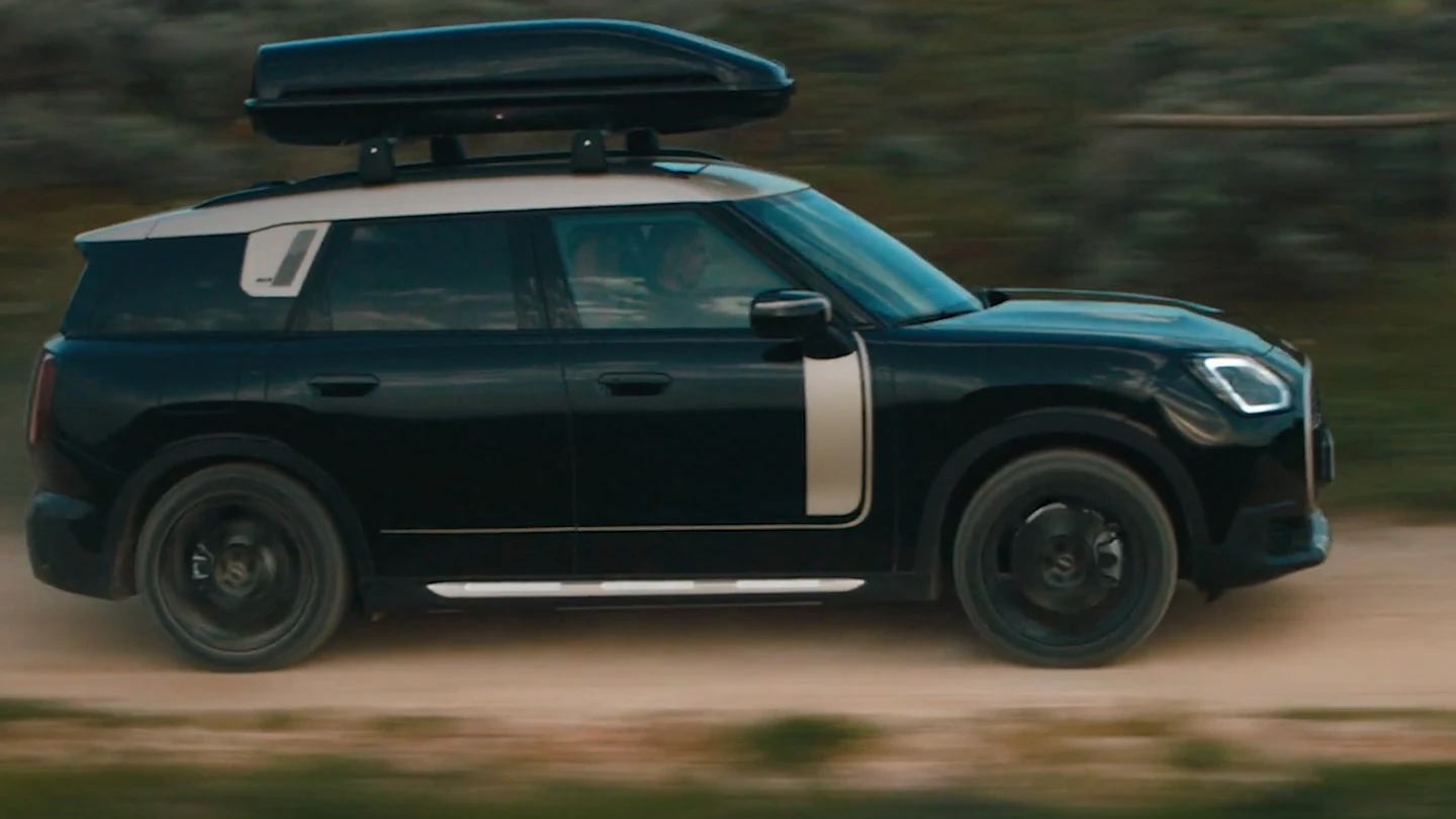 Offroad rijdende MINI Countryman in Midnight Black metallic met 19 inch John Cooper Works Runway Spoke wielen in het zwart. 