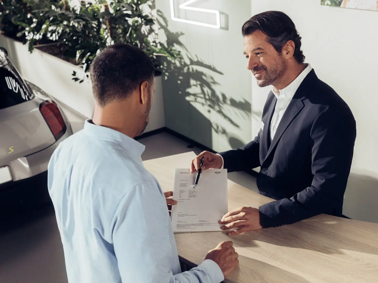 Een service-assistent van een MINI partner adviseert een klant welke opties er zijn qua MINI bandenverzekering.