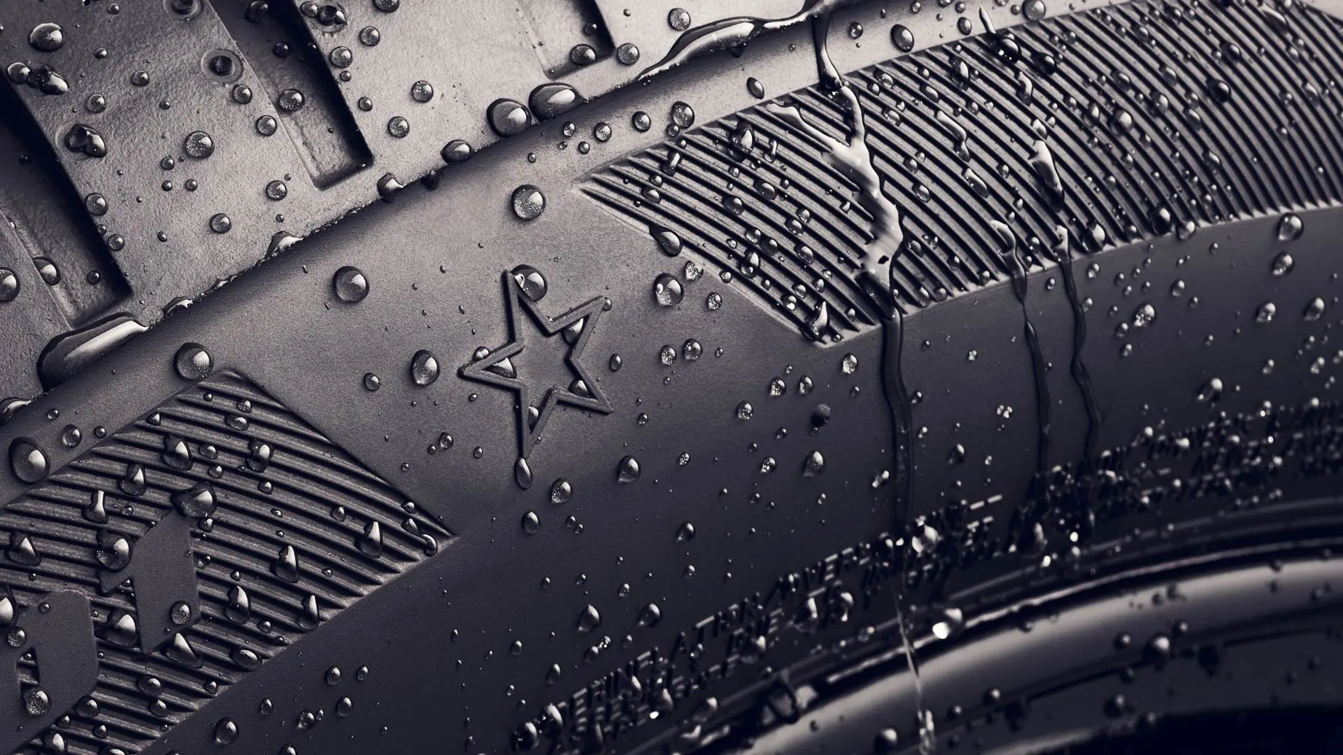 Close-up van de zijwand van een band met de stermarkering, waaruit blijkt dat deze band is goedgekeurd voor optimale prestaties op MINI voertuigen. 