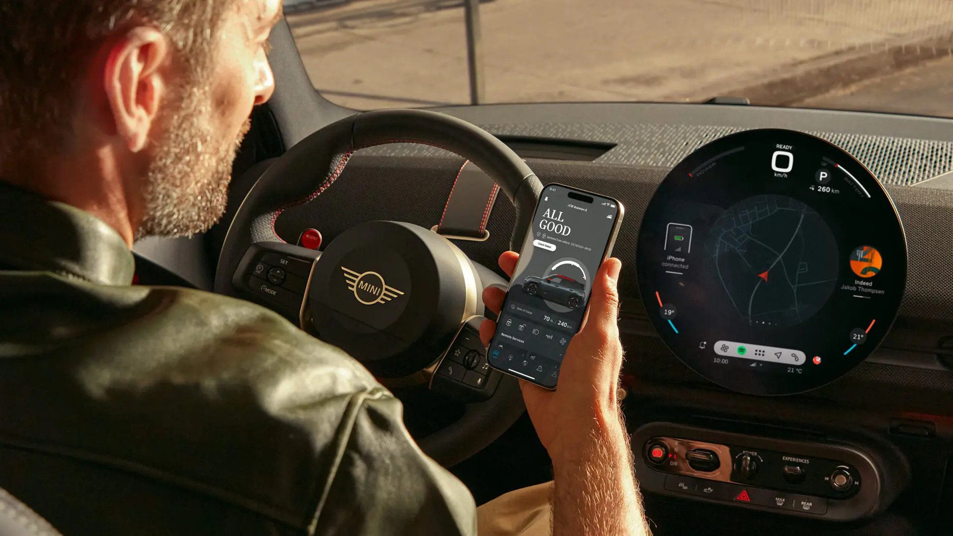 MINI bestuurder die de MINI app op zijn telefoon gebruikt voor navigatiediensten.