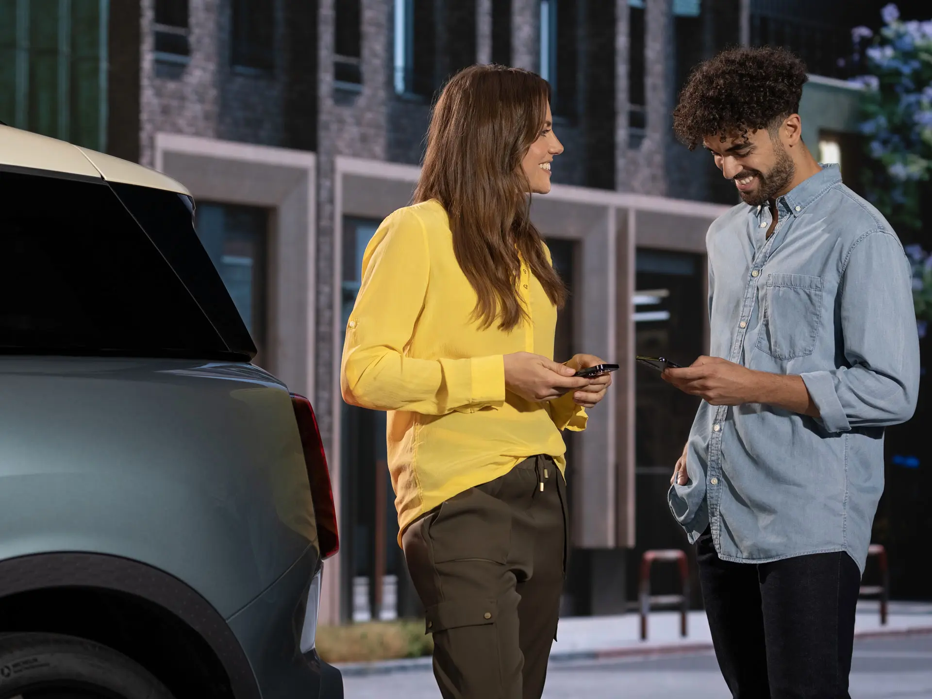 Man en vrouw staan naast een MINI en bellen met een MINI servicepartner