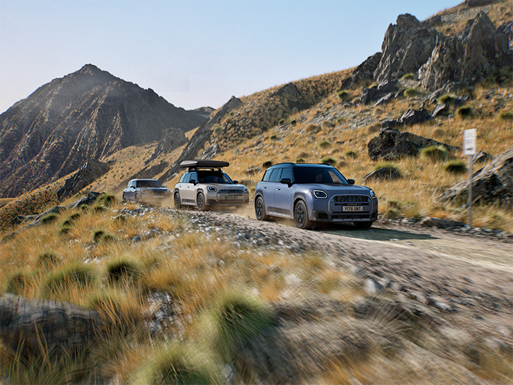 Afbeelding van meerdere MINI Countryman Untamed Edition modellen die offroad door de bergen rijden.