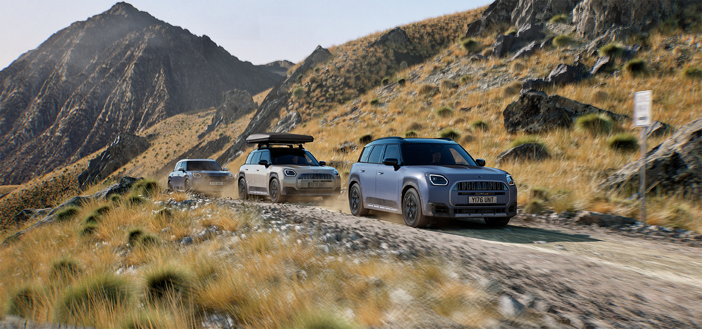 Afbeelding van meerdere MINI Countryman Untamed Edition modellen die offroad door de bergen rijden.