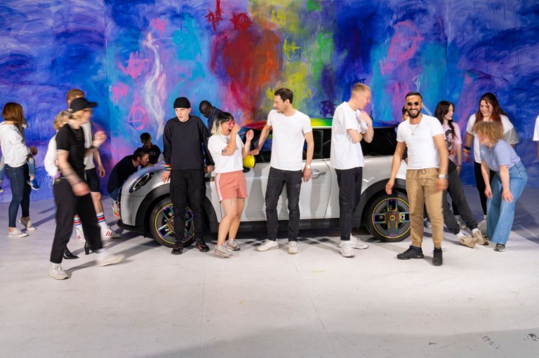 Mensen poseren met een MINI Cooper SE voor MINI's "We are all different, but pretty good together" campagne.